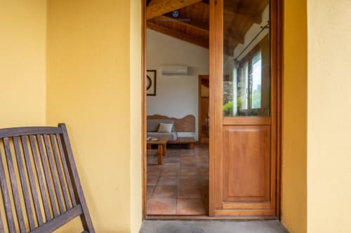 Ingresso giallo con porta in legno che si apre sulla Suite Locandiere presso House Live Express a Quartu Sant'Elena