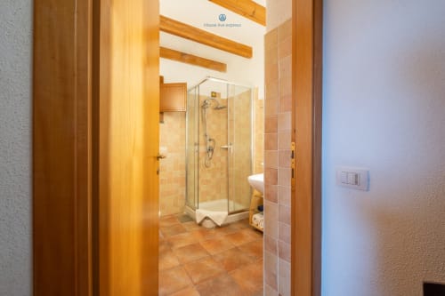 Bagno moderno con box doccia in vetro presso House Live Express, Quartu Sant'Elena, con pavimenti in cotto e legno