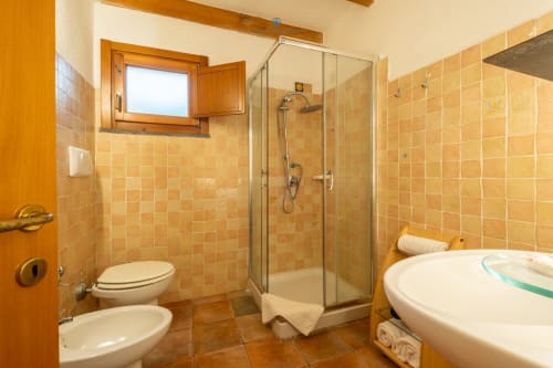 Bagno della Suite Locandiere presso House Live Express con doccia, vasca, WC, bidet e piastrelle in terracotta