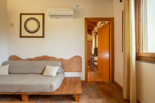 Suite Locandiere presso House Live Express con letto in legno, biancheria grigia, panchetta in legno, orologio incorniciato, aria condizionata