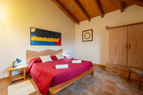 Camera Suite Locandiere con letto rosso, travi in legno e vista sul giardino presso House Live Express, Quartu Sant'elena