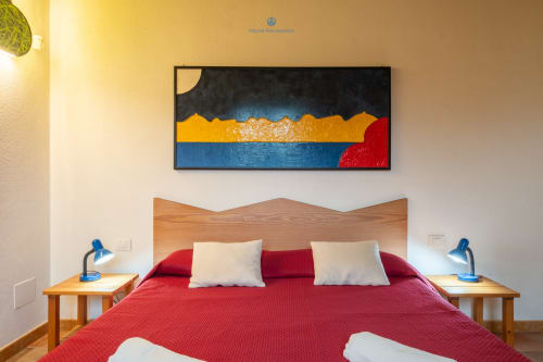 Camera Locandiere Suite presso House Live Express con letto rosso, testiera in legno e coloratevi dipinti montani a Quartu