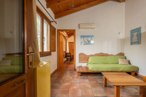 Suite Locandiere presso House Live Express con futon verde, arredi in legno e pavimenti in cotto a Quartu Sant'elena