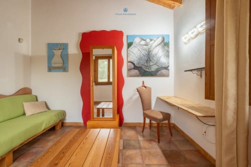 Suite Locandiere presso House Live Express, Quartu Sant'elena: camera luminosa con divano verde lime, specchio rosso, arredamento in legno
