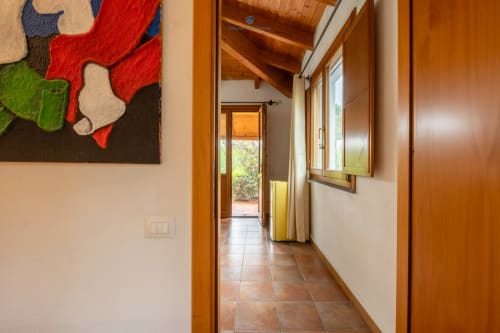 Corridoio della Suite Locandiere a House Live Express con travi in legno, pavimento in cotto e accesso alla vista del giardino a Quartu