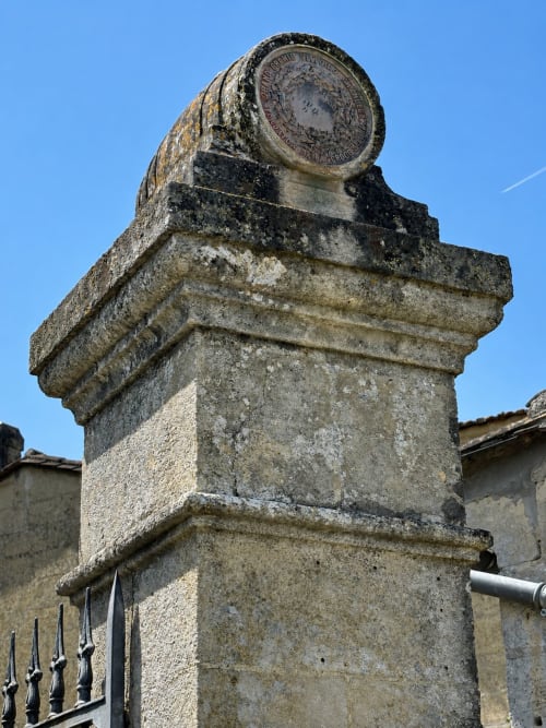 Pilier de pierre historique orné d'un emblème au Château Alto Cormeil à Saint-Émilion