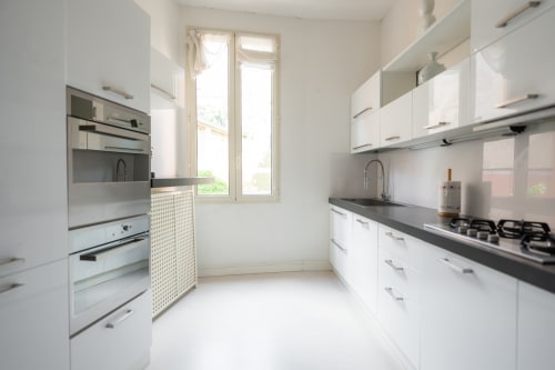 Cucina bianca moderna con piano cottura a gas e doppi forni all'appartamento Perla Marina di Finale Ligure