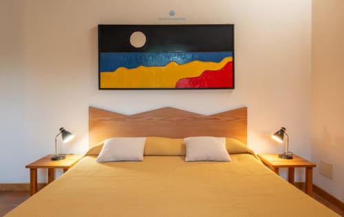 Camera da letto luminosa presso House Live Express con letto in legno, biancheria gialla, due cuscini bianchi, arte paesaggistica moderna e comodino