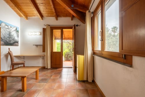 Suite Locandiere 2 presso House Live Express a Quartu Sant'Elena con travi in legno, pavimenti in cotto e porte con vista giardino