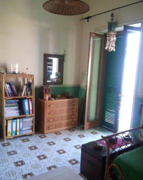 Camera da letto in cottage a Bienbi Woods Three Houses, Boscotrecase, con mobili in legno, parete verde e piastrelle decorate