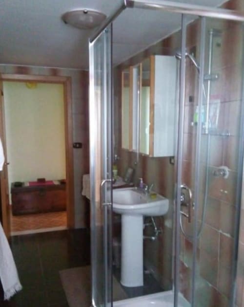 Bagno moderno con lavabo a colonna, box doccia in vetro e pareti piastrellate alla cottage Bienbi Woods a Boscotrecase