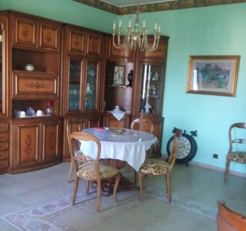 Elegante sala da pranzo del cottage Bienbi Woods a Boscotrecase con tavolo rotondo, mobili in legno e pareti turchesi