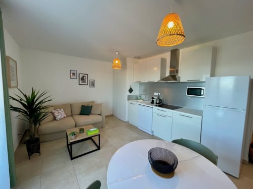 Modern T3 apartment at Résidence Marina di Bravone with open kitchen, dining area, and lounge with sea views