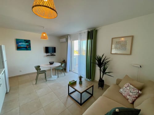 Marina di Bravone apartment in Linguizzetta with living area, dining table, beige sofa, and sea view balcony access