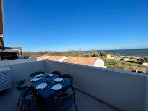 Rooftop terrace with dining table overlooking sea at Résidence Marina di Bravone, Linguizzetta