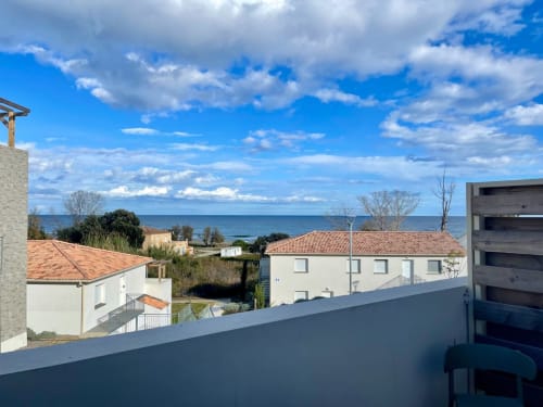 Balcon d'appartement avec vue mer à Marina di Bravone, dominant les maisons côtières et les eaux méditerranéennes de Linguizzetta