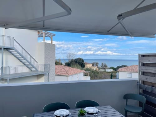 Terrasse vue mer à la Résidence Marina di Bravone en Corse avec table à manger et store rétractable