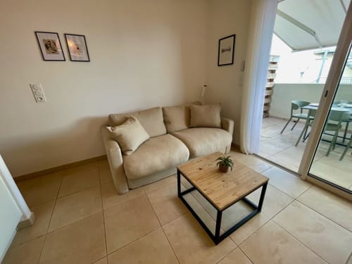 Canapé beige avec table basse en bois dans un salon moderne de la Résidence Marina di Bravone, Linguizzetta