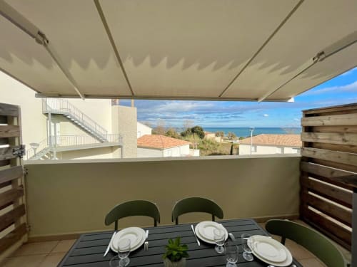 Terrazza fronte mare di Résidence Marina di Bravone con vista sul mare, zona pranzo e tenda da sole retrattile