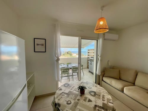 Appartamento T3 Marina di Bravone con soggiorno, balcone vista mare, divano e accesso diretto alla spiaggia a Linguizzetta