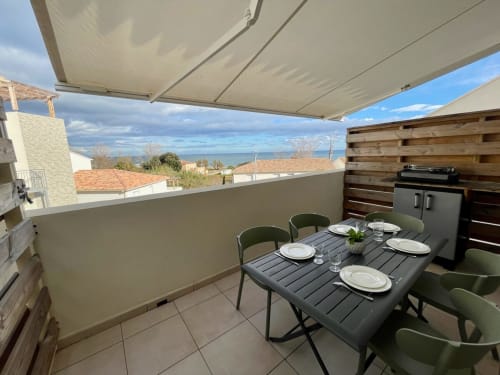 Terrazza sul tetto a Marina di Bravone con area dining vista mare, tenda retrattile e paesaggio costiero