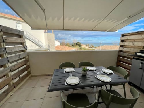 Terrazza Marina di Bravone con tavolo da pranzo, vista mare e tenda retrattile a Linguizzetta