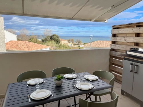 Terrazza fronte mare della Résidence Marina di Bravone con tavolo da pranzo, vista sul mare e cucina esterna a Linguizzetta