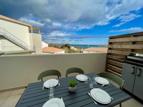 Terrazza fronte mare della Résidence Marina di Bravone con tavolo da pranzo, vista sul mare e accesso alla spiaggia a Linguizzetta