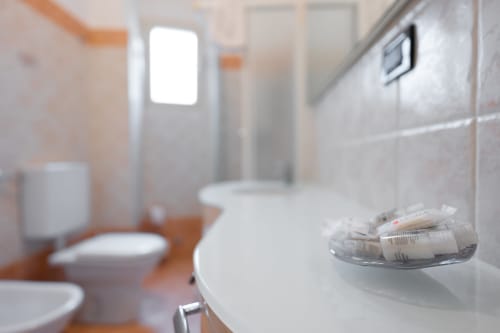 Lavabo da bagno con articoli da toilette presso l'hotel Welcome Holiday a Finale Ligure, Italia