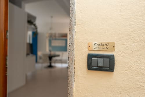 Targhetta Traballi Vincenti sopra gli interruttori della luce nella camera dell'hotel Perla Marina, Finale Ligure