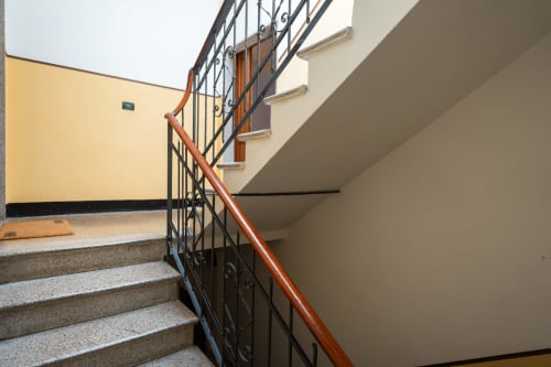 Scala interna con corrimano in legno e ringhiera in metallo presso l'Hotel Welcome Holiday a Finale Ligure, Italia
