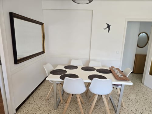 Modern dining room in Rosas apartment with white table, wooden chairs, and minimalist decor near beach and restaurants