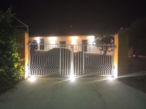 Cancellata d'ingresso illuminata di Villa Maria di notte nella campagna di Roggiano Gravina
