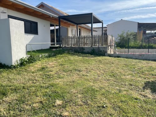 Appartamento in campagna Villa Maria con patio, muri bianchi, pergolato nero e giardino curato a Roggiano Gravina