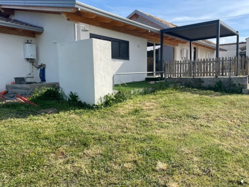 Appartamento di Villa Maria in campagna con muri bianchi, pergolato in legno, terrazza e prato verde a Roggiano Gravina, Italia