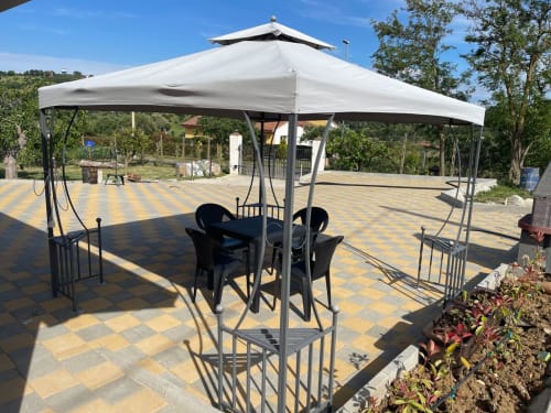Zona pranzo all'aperto di Villa Maria con veranda bianca, sedie nere e patio decorato nella campagna di Roggiano Gravina