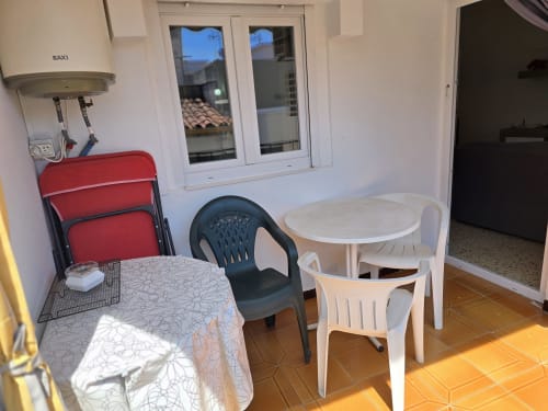 Family apartment dining area in Rosas with tables, chairs, water heater, and balcony doors overlooking the city