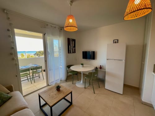 Modern apartment at Résidence Marina di Bravone with sea view, dining area, kitchen, and beach access via balcony