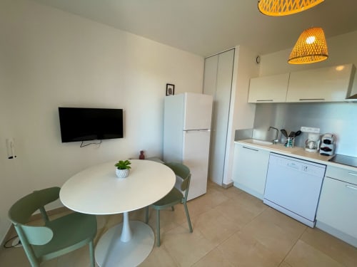 Modern apartment kitchen and dining area at Résidence Marina di Bravone, Linguizzetta with round table and sea view