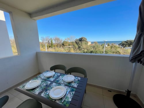 Balcony dining setup at Marina di Bravone, Linguizzetta overlooking the beach and sea