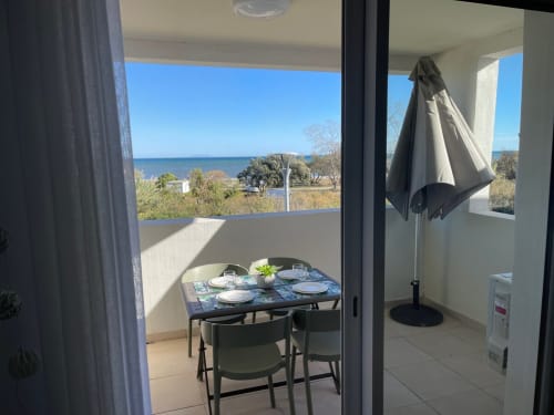 Balcone affacciato sul mare della Résidence Marina di Bravone con tavolo da pranzo e ombrellone, Linguizzetta
