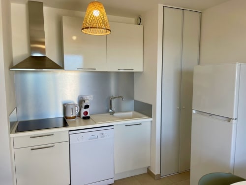 Cucinetta moderna nell'appartamento T2 della Résidence Marina di Bravone, Linguizzetta con mobili bianchi e acciaio inox