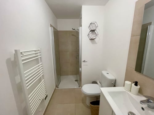Bagno moderno presso la Résidence Marina di Bravone con doccia, WC, lavabo, scaldarifiuti e specchio