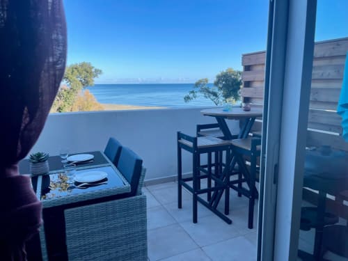 Coastal apartment balcony at Résidence Marina di Bravone with sea view, dining table, and beach access in Linguizzetta