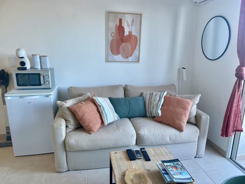 Cozy T2 apartment living room at Résidence Marina di Bravone, Linguizzetta with beige sofa and coastal decor