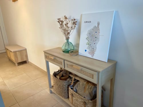 Corsica map artwork on wooden console table at Résidence Marina di Bravone in Linguizzetta with dried flowers and woven
