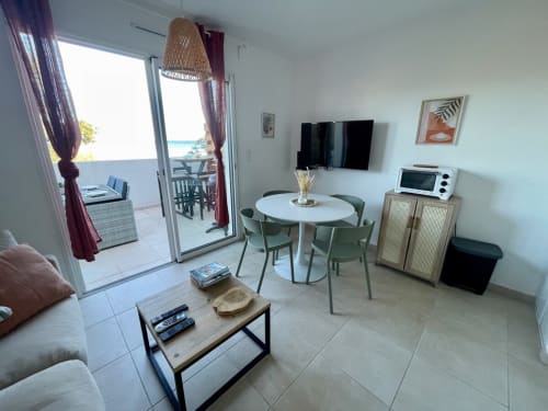 Modern apartment living room at Résidence Marina di Bravone in Corsica with coastal views, dining area, and contemporary