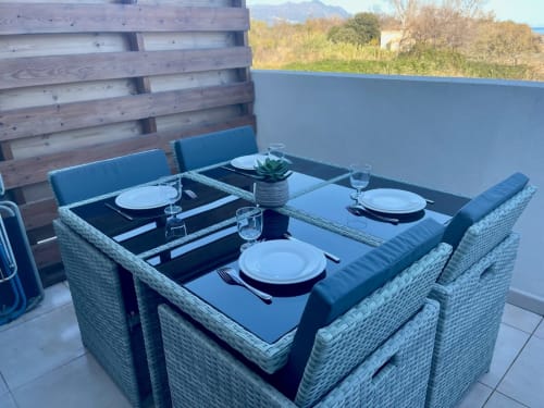 Outdoor dining table at Résidence Marina di Bravone, Linguizzetta, set with place settings and water glasses