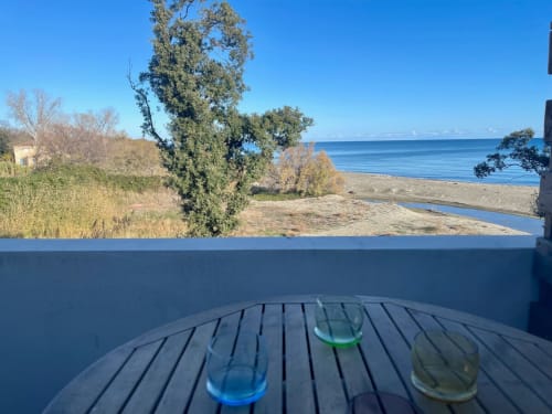 Balcony view at Marina di Bravone hotel, Linguizzetta, overlooking beach, sea, and coastal landscape with drinks