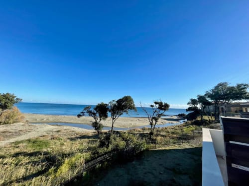 Beachfront view from Marina di Bravone apartment in Corsica with sea, sandy beach, and Mediterranean landscape